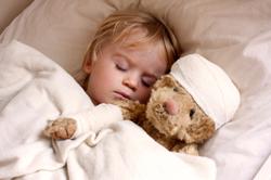 Child sleeping with a teddy bear
