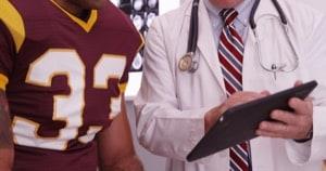 Football player getting checked by a doctor