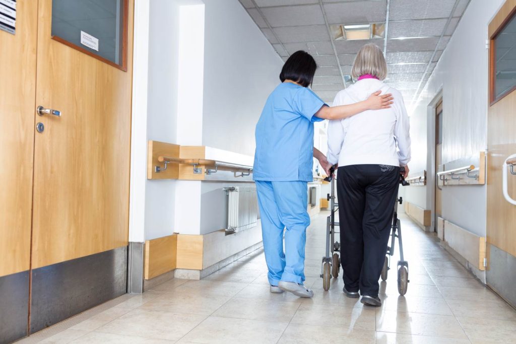 nursing home resident walking with nurse